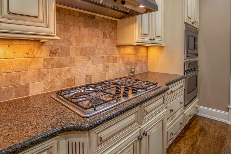 Kitchen with granite + tiled backsplash