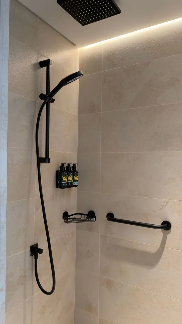 Sleek tiled shower with black hardware