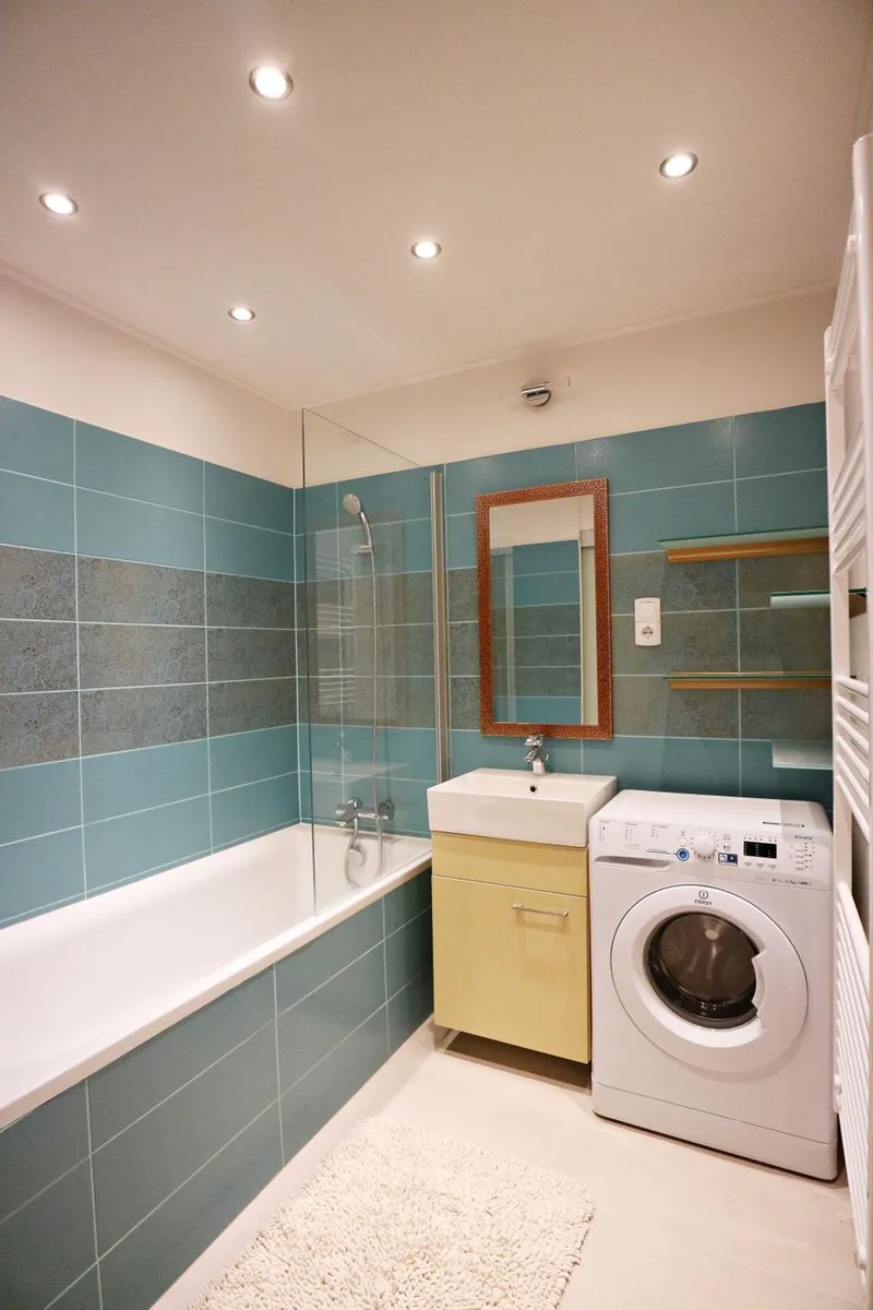 Green-tiled bathroom with freestanding bath